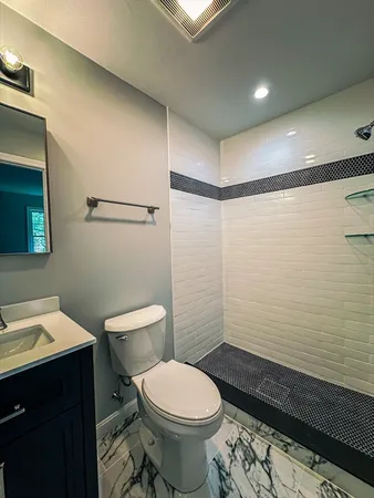 a white toilet sitting next to a bathroom sink