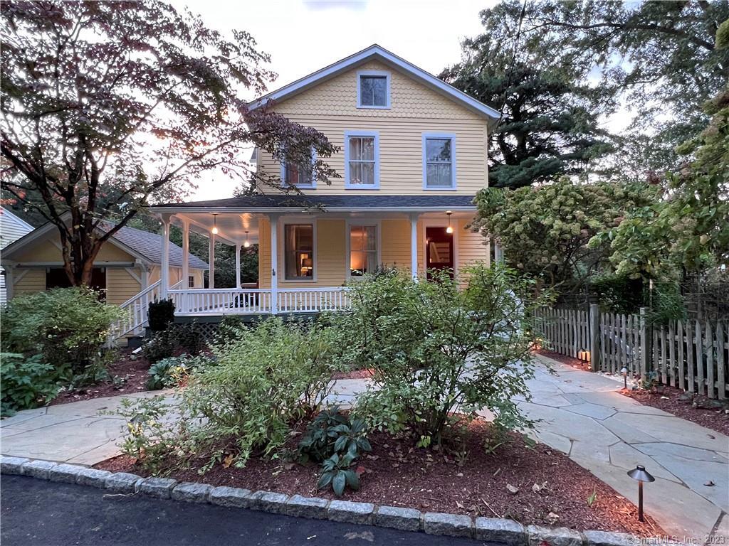 a front view of a house with a yard and potted plants