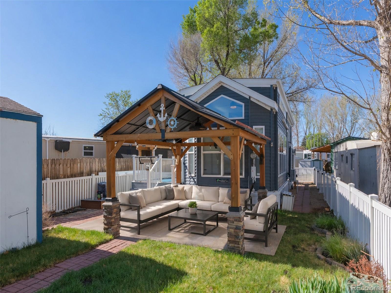188 Kiowa Road Weldona, CO 80653 - Photo 12 of 34 a front view of a house with a garden and outdoor seating