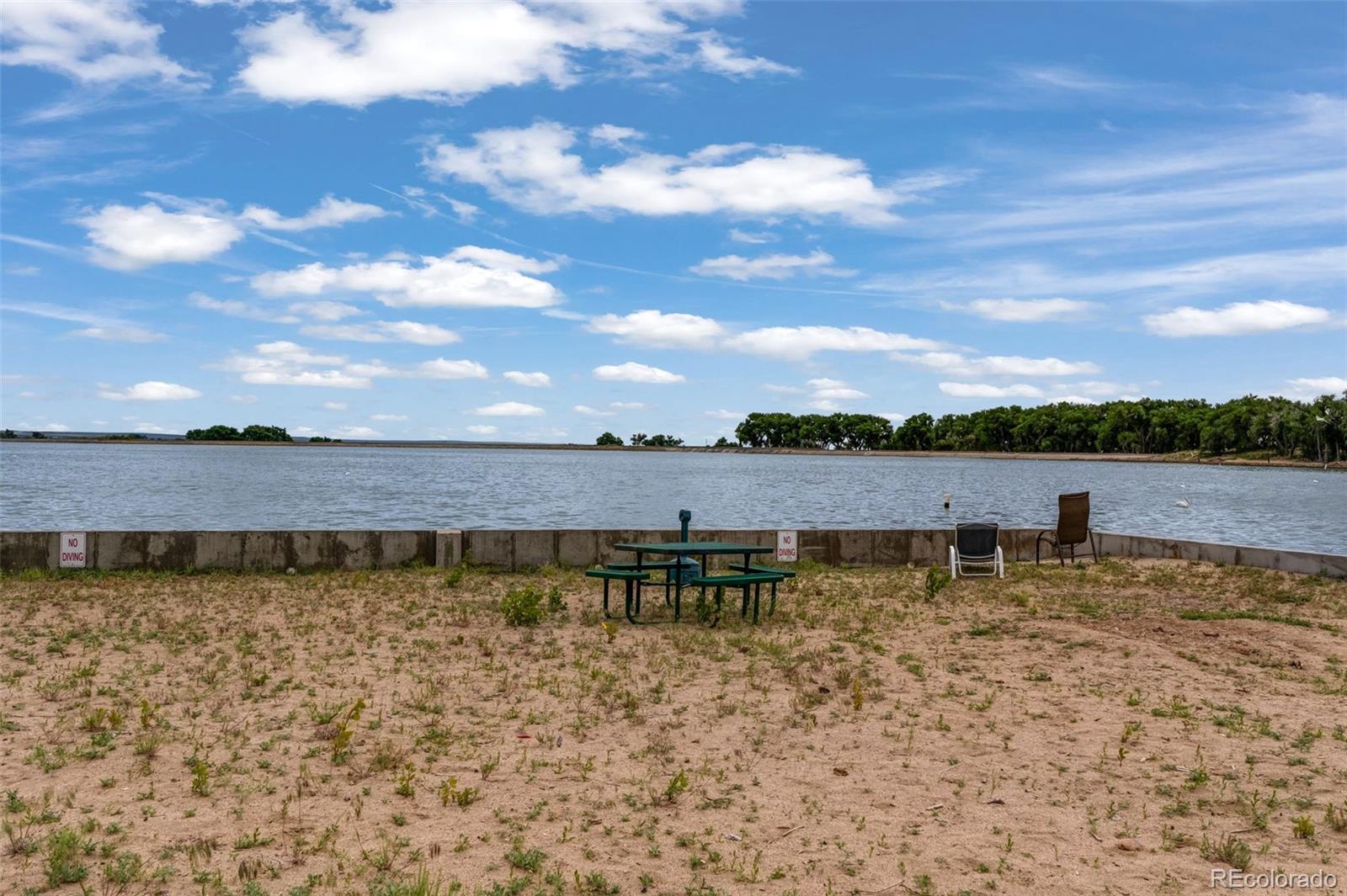 188 Kiowa Road Weldona, CO 80653 - Photo 26 of 34 a view of a lake with houses in the back