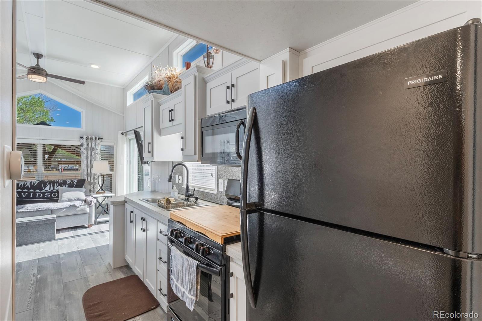 188 Kiowa Road Weldona, CO 80653 - Photo 6 of 34 a kitchen with stainless steel appliances granite countertop a refrigerator a oven a sink and white cabinets