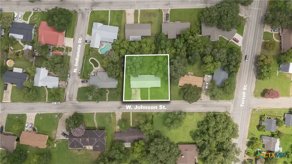 aerial view of a brick house with a yard