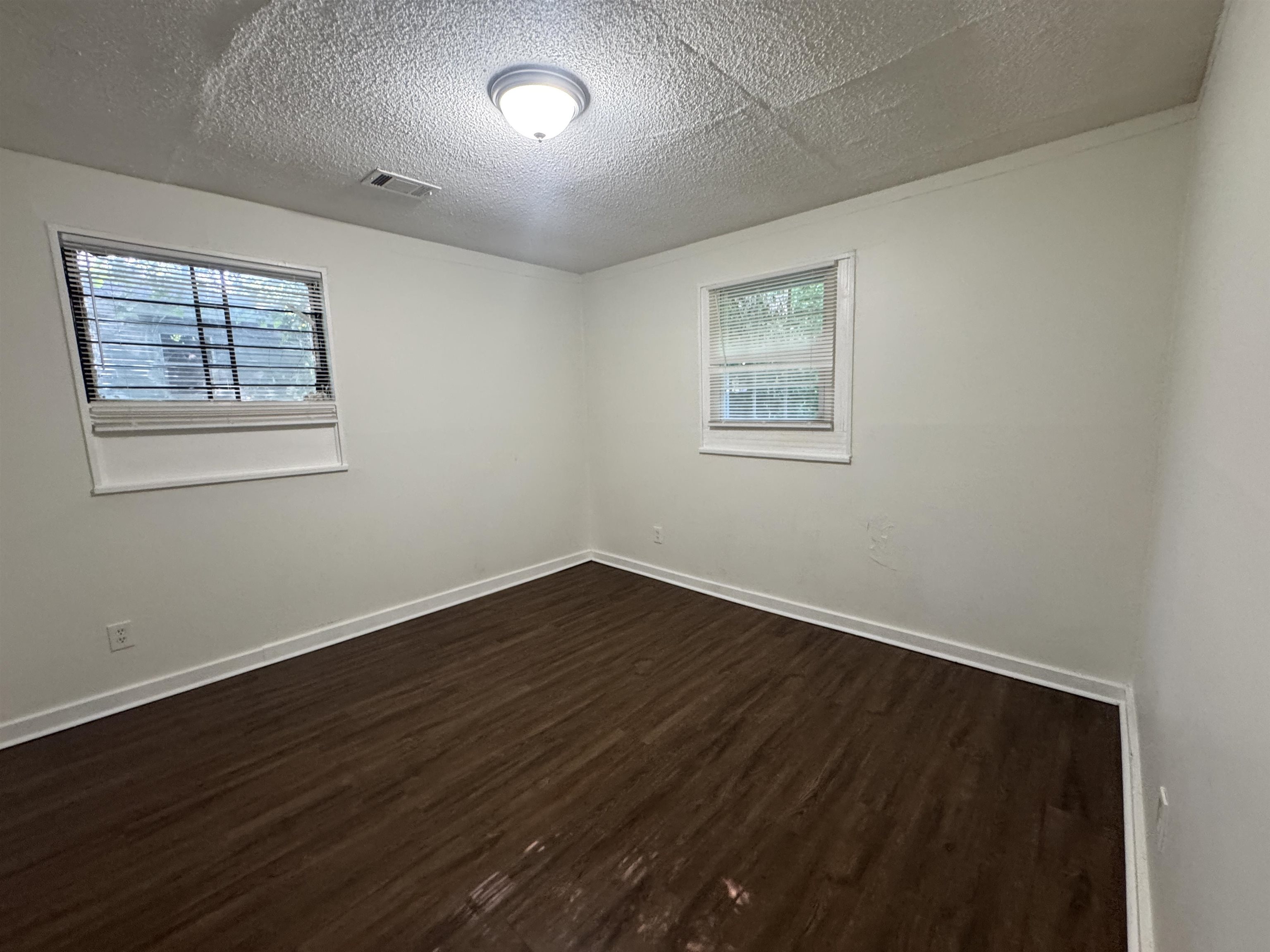 761 Harahan Road Memphis, TN 38109 - Photo 5 of 9 Spacious room featuring wood-finish flooring, white walls, and two windows
