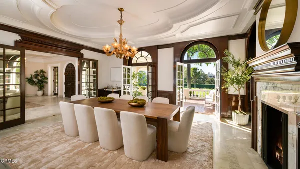a view of a dining room with furniture a chandelier and a rug
