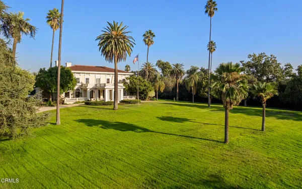 a view of a swimming pool with lawn chairs and a big yard