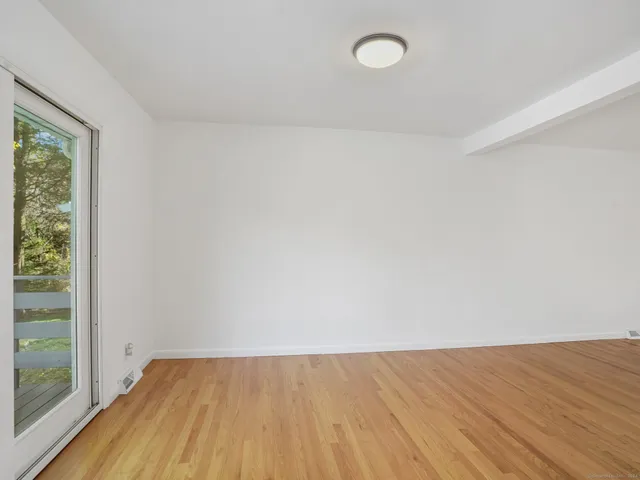 a view of a room with wooden floor and white walls