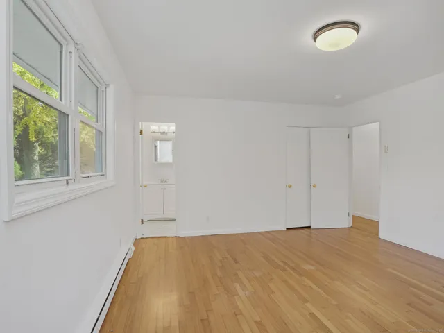 a view of empty room with window and ceiling fan