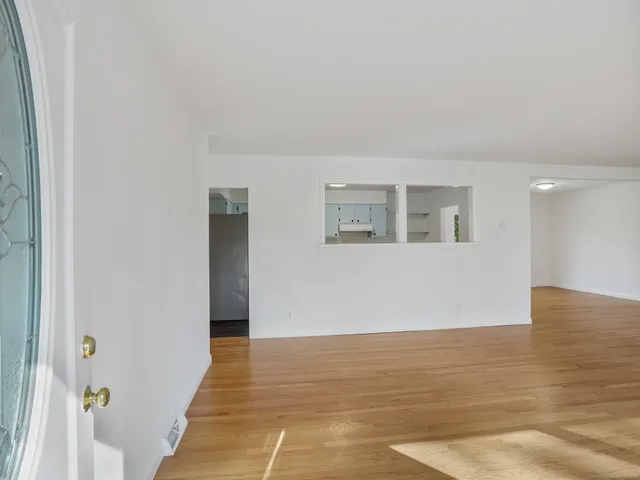 a view of an empty room with wooden floor
