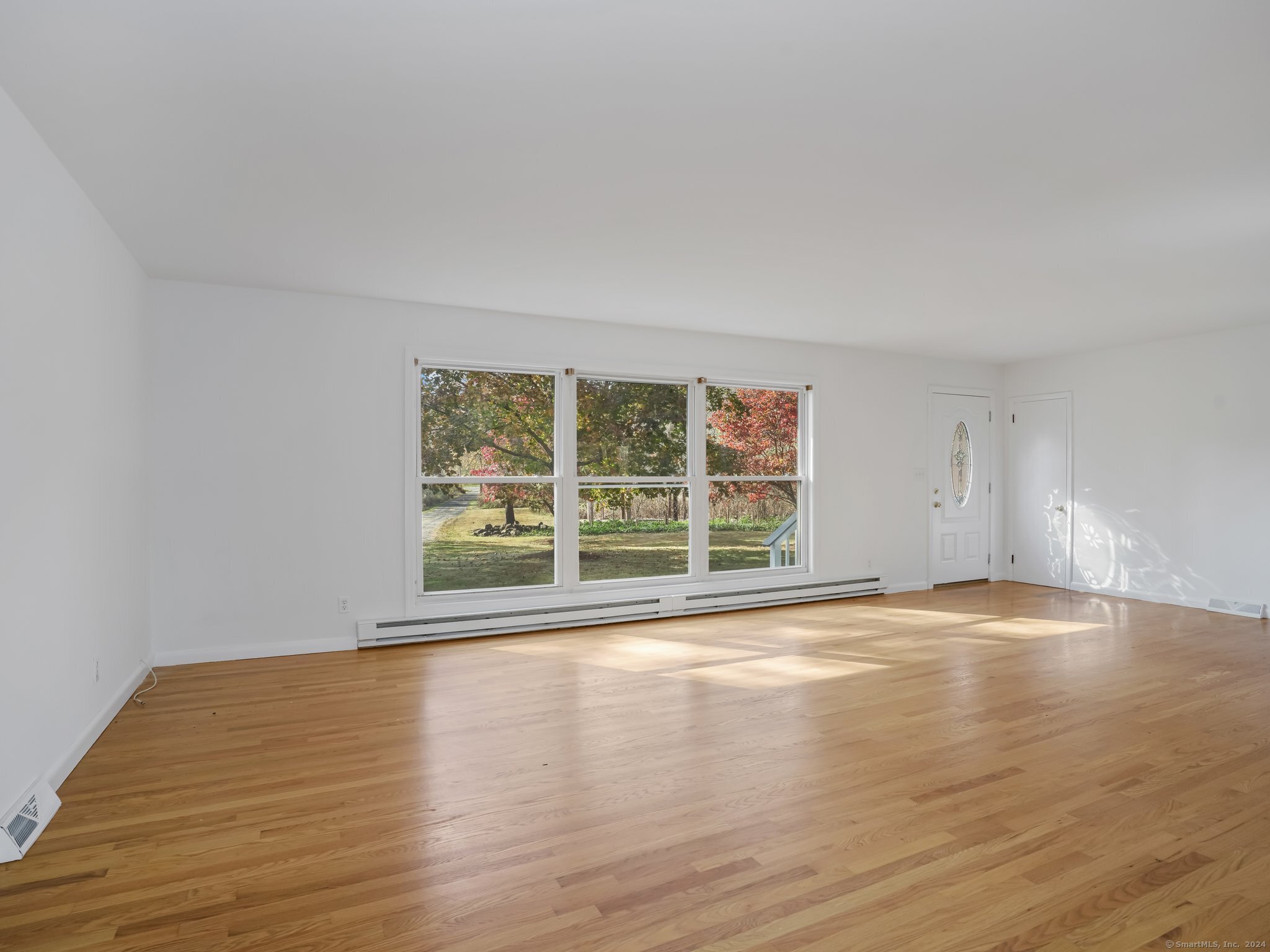 488 Sport Hill Road Easton, CT 06612 - Photo 4 of 32 a view of an empty room with wooden floor and a window