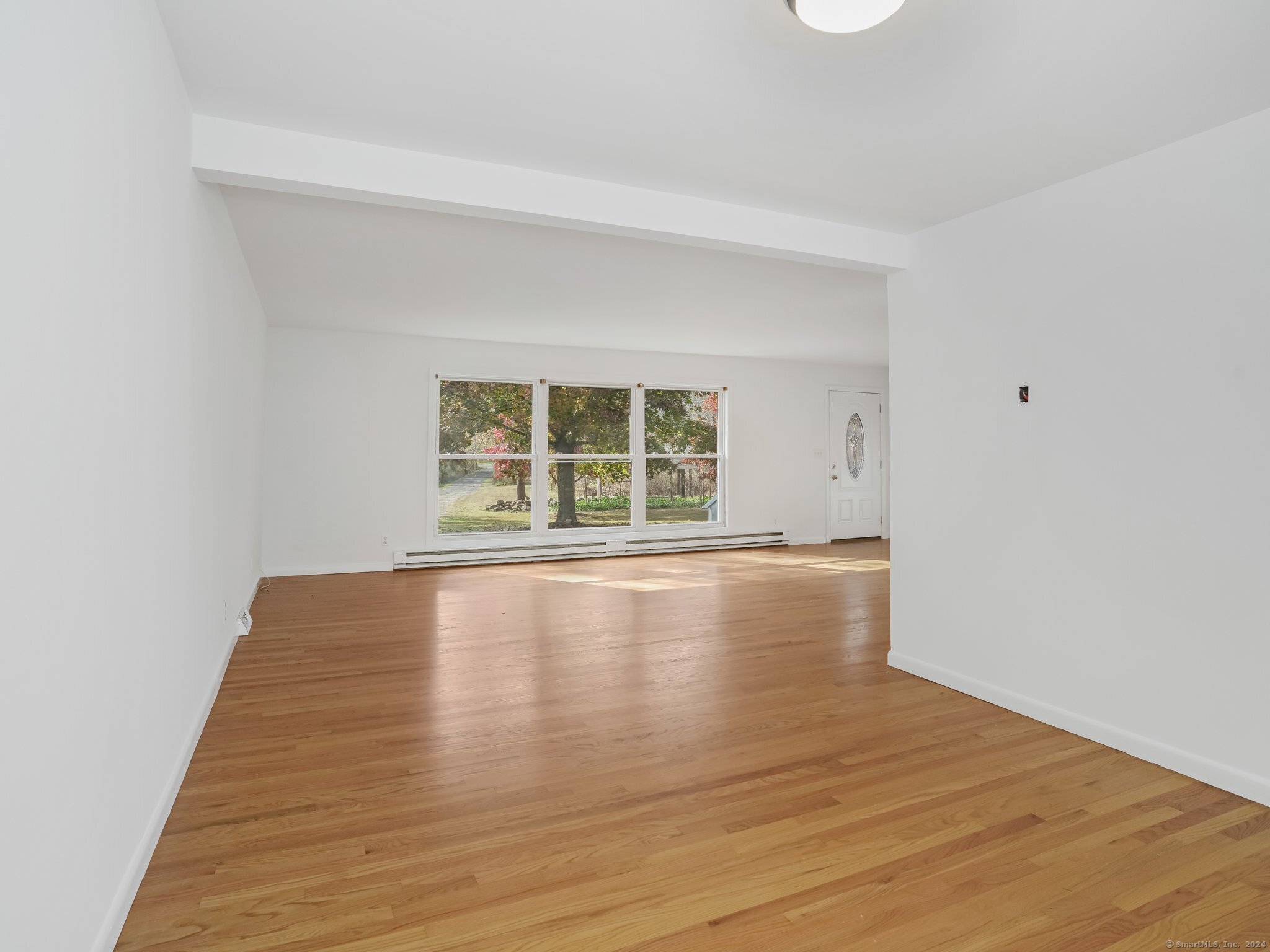 488 Sport Hill Road Easton, CT 06612 - Photo 6 of 32 a view of an empty room with wooden floor and a window