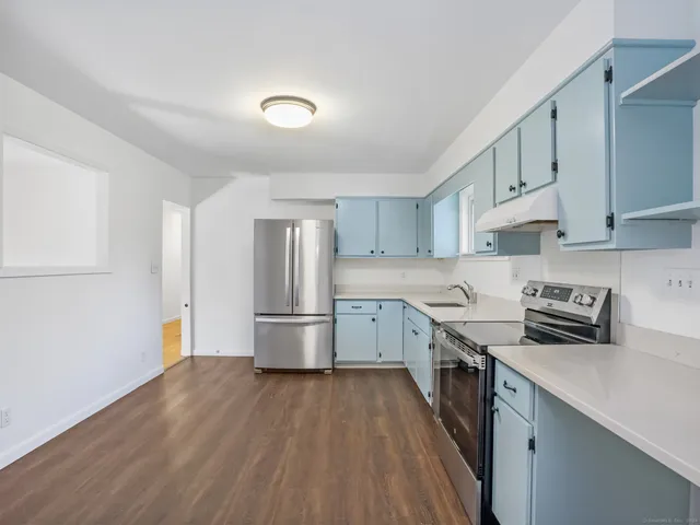a kitchen with a sink a refrigerator and a stove