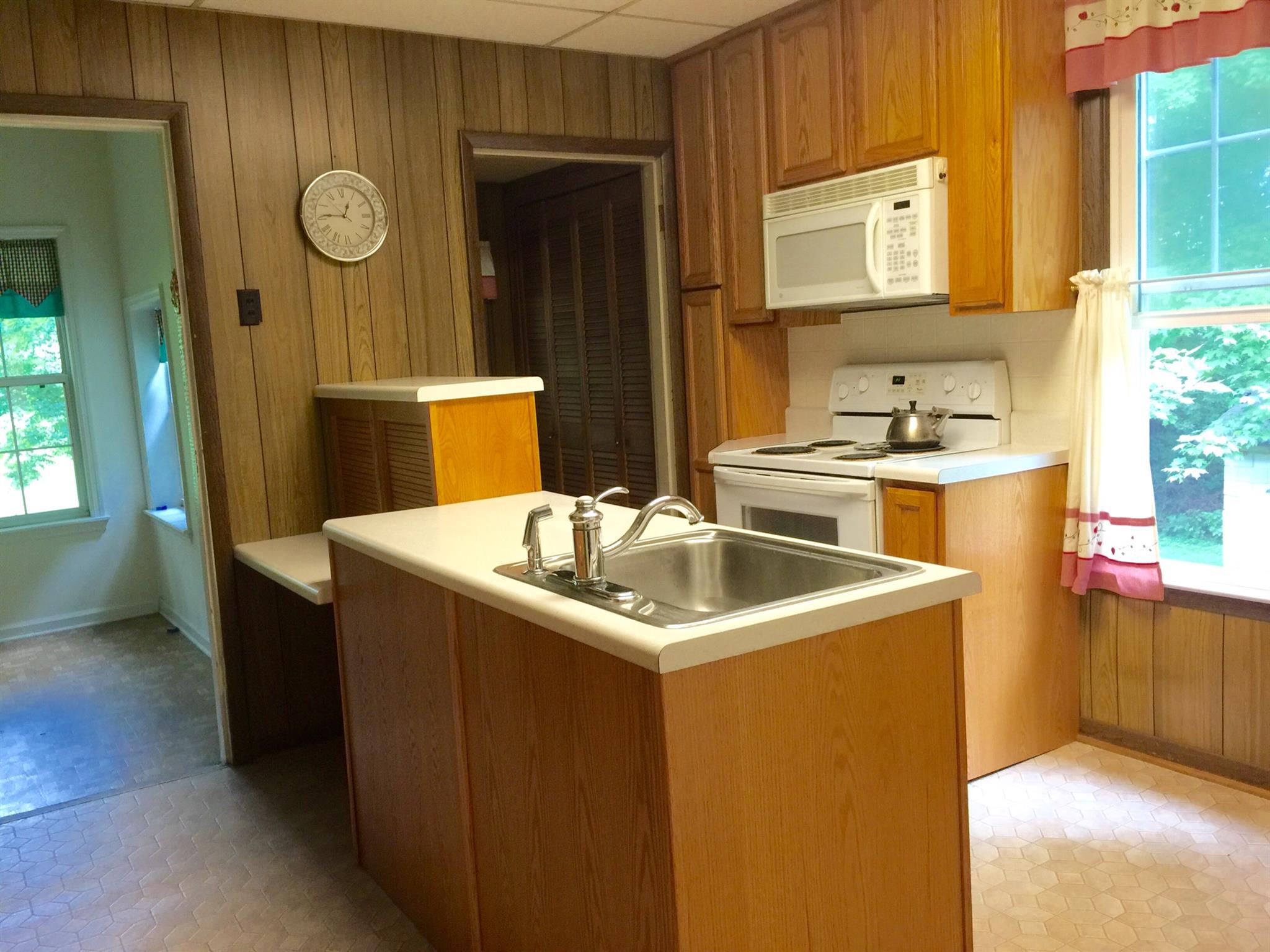 128 East Campbell Road Madison, TN 37115 - Photo 11 of 26 An island in the kitchen houses a dishwasher & sink. Extra cabinetry along the wal