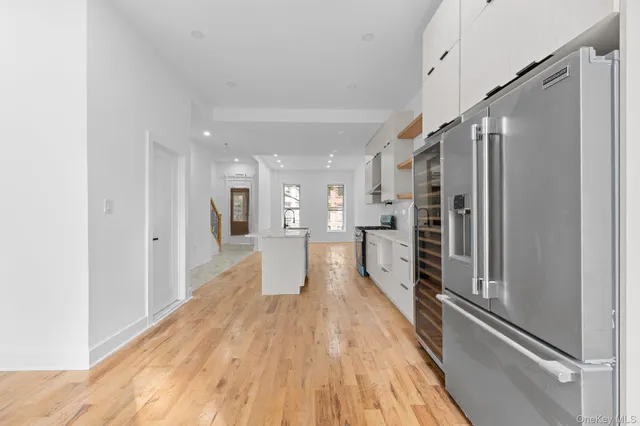 a view of a kitchen with a refrigerator and a stove top oven