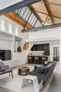 a living room with furniture a flat screen tv and a window