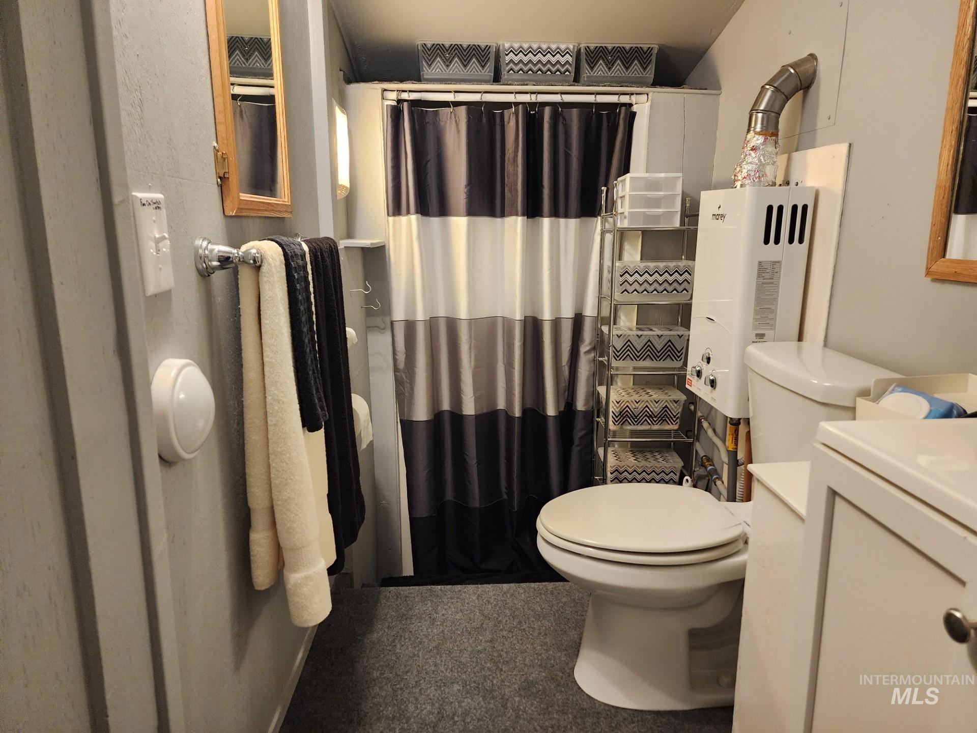 235 5th Street Grand View, ID 83624 - Photo 13 of 22 Compact bathroom featuring a white toilet, white vanity with brushed nickel hardware, and a shower with a striped curtain