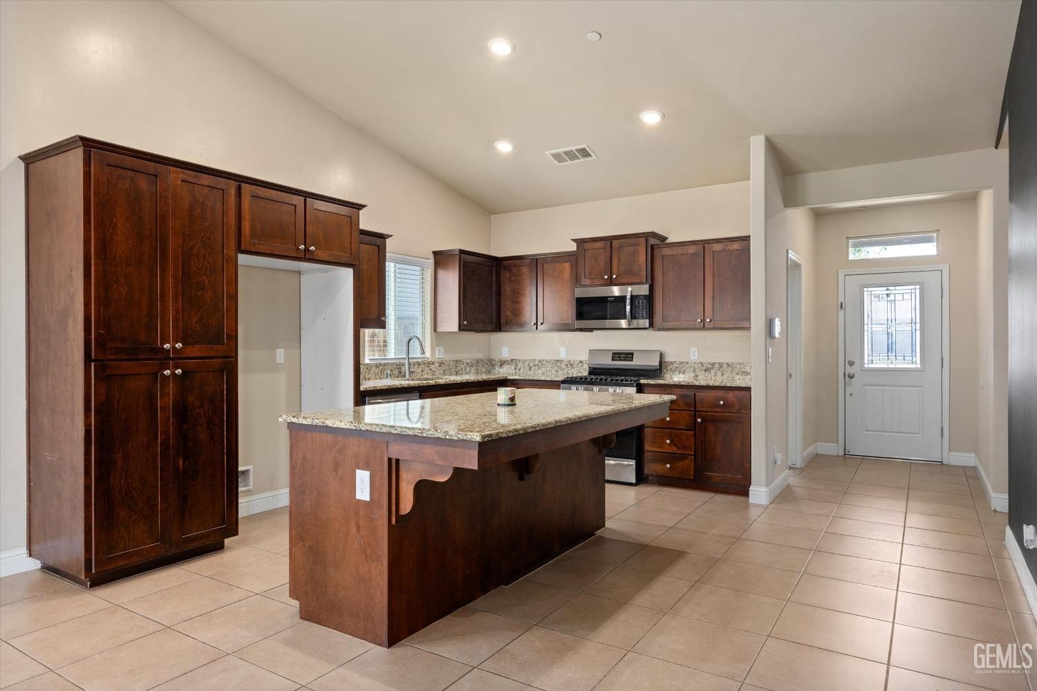 Undisclosed Address Shafter, CA 93263 - Photo 5 of 29 a large kitchen with stainless steel appliances granite countertop a stove and a refrigerator