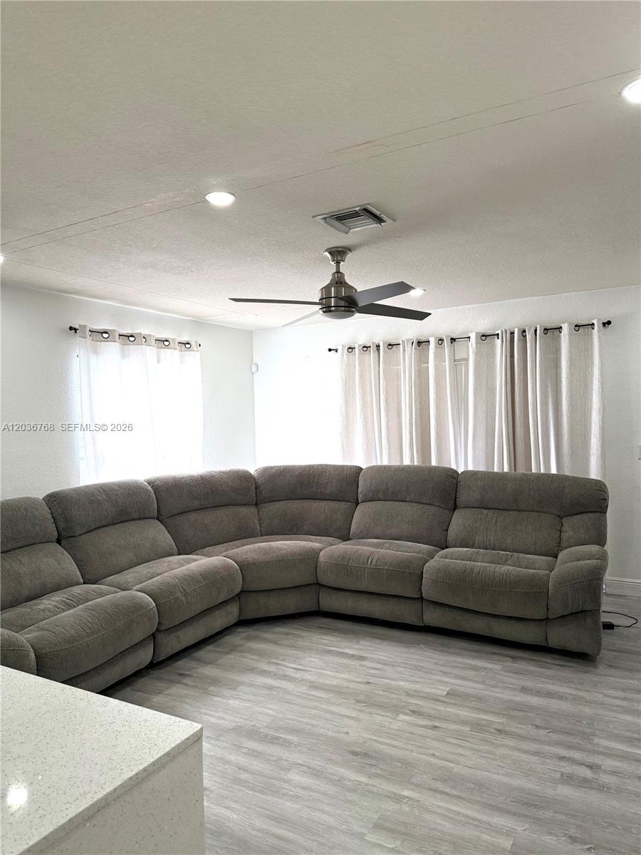 2432 Southwest 99th Way Miramar, FL 33025 - Photo 14 of 17 a living room with furniture and a wooden floor