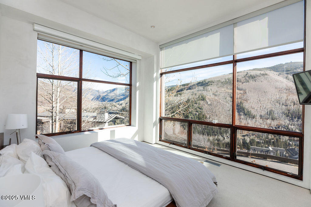 1449 Buffehr Creek Road Vail, CO 81657 - Photo 20 of 41 a bedroom with a large window and a bed