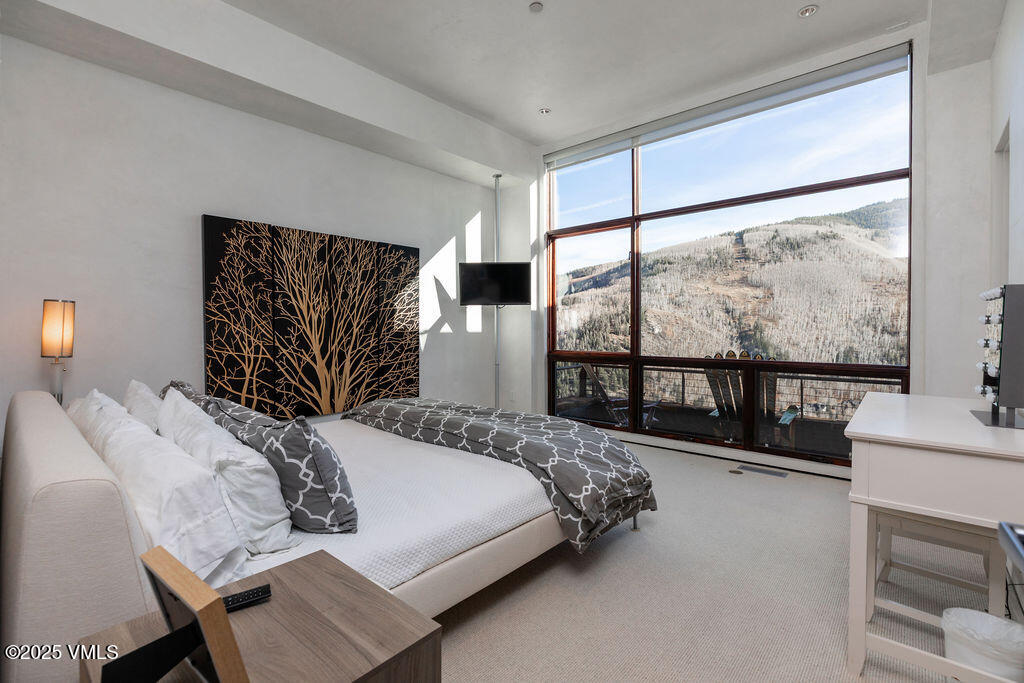 1449 Buffehr Creek Road Vail, CO 81657 - Photo 22 of 41 a bedroom with a large bed and a large window