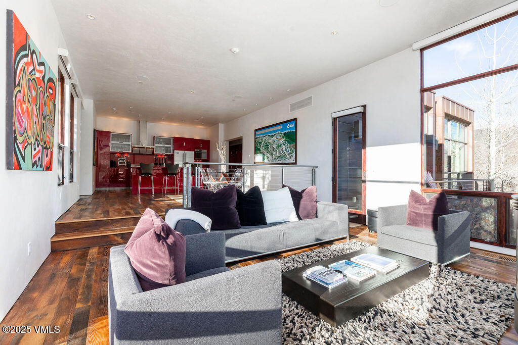 1449 Buffehr Creek Road Vail, CO 81657 - Photo 7 of 41 a living room with furniture couches and a dining table with wooden floor