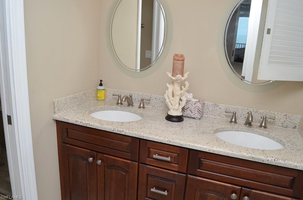 5550 Heron Point Drive, Unit 1804 Naples, FL 34108 - Photo 14 of 17 a bathroom with double vanity sinks and a mirror