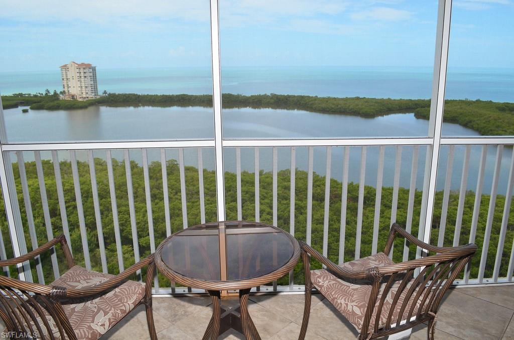 5550 Heron Point Drive, Unit 1804 Naples, FL 34108 - Photo 2 of 17 a view of a chair and tables in the balcony