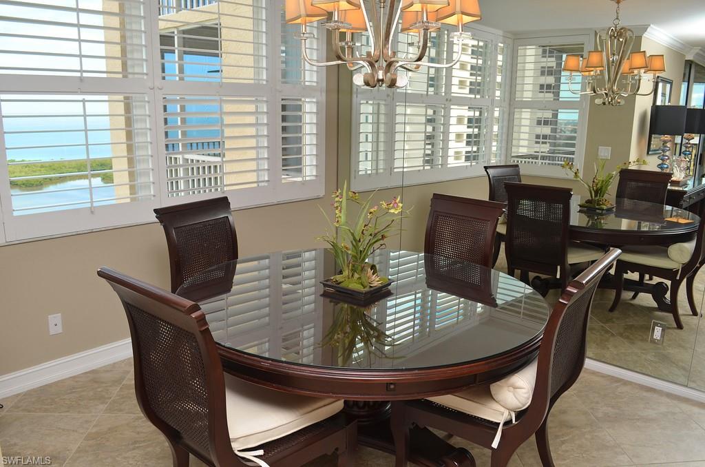 5550 Heron Point Drive, Unit 1804 Naples, FL 34108 - Photo 8 of 17 a view of a dining room with furniture and wooden floor