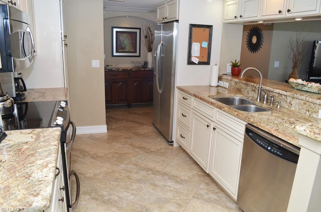5550 Heron Point Drive, Unit 1804 Naples, FL 34108 - Photo 9 of 17 a bathroom with a granite countertop sink a mirror and vanity