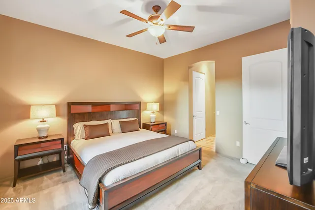 a bedroom with a bed and a ceiling fan