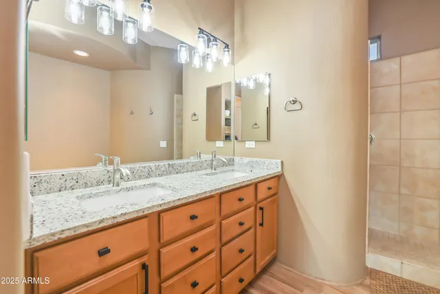a bathroom with a granite countertop sink mirror and shower