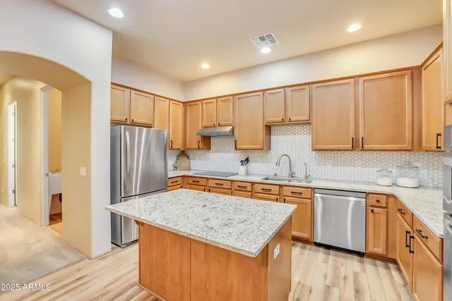 a kitchen with stainless steel appliances granite countertop a sink stove and refrigerator