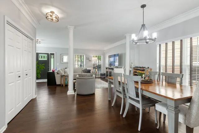 a view of a dining room and livingroom with furniture wooden floor a chandelier