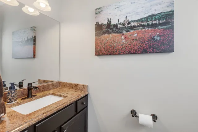 a bathroom with a granite countertop sink and a mirror