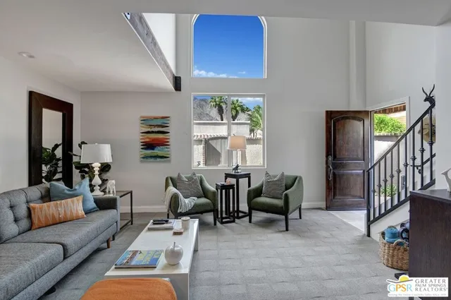 a living room with furniture fireplace and a large window