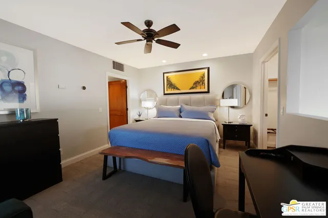 a bedroom with a bed and a painting on the wall