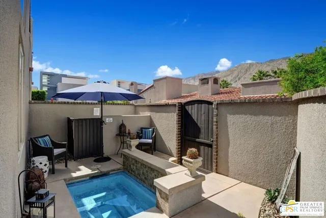 a patio with a table and chairs under an umbrella