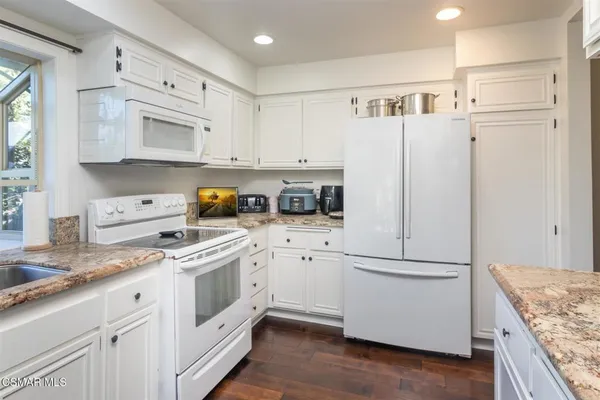 a kitchen with white cabinets and white appliances
