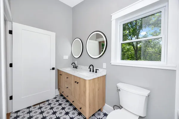 a bathroom with a double vanity sink and a mirror