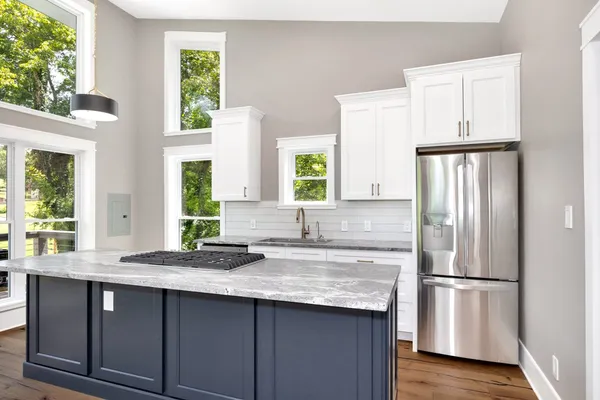 a kitchen with a stove a sink and a window