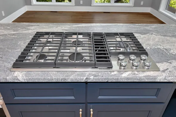 a view of an empty room with wooden floor and a large window