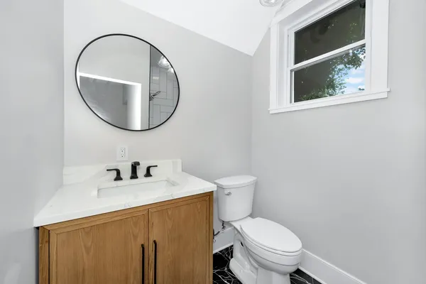 a bathroom with a toilet a sink and mirror