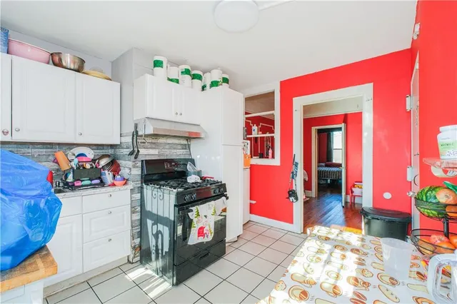 a view of a dining room with furniture a chandelier and a window
