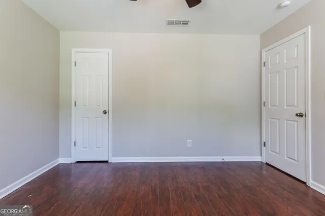 a view of an empty room with wooden floor