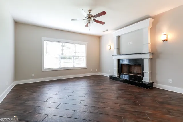 an empty room with windows and a fireplace