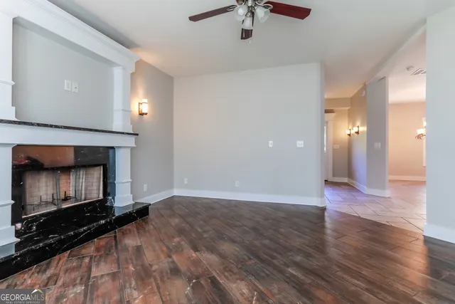 a view of empty room with wooden floor and fireplace