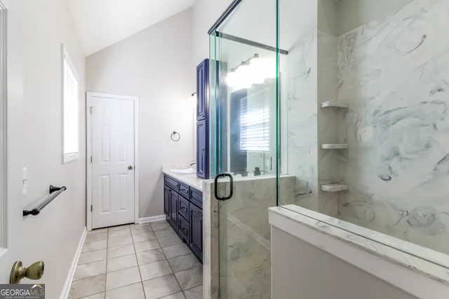 a bathroom with a granite countertop sink a mirror and a shower
