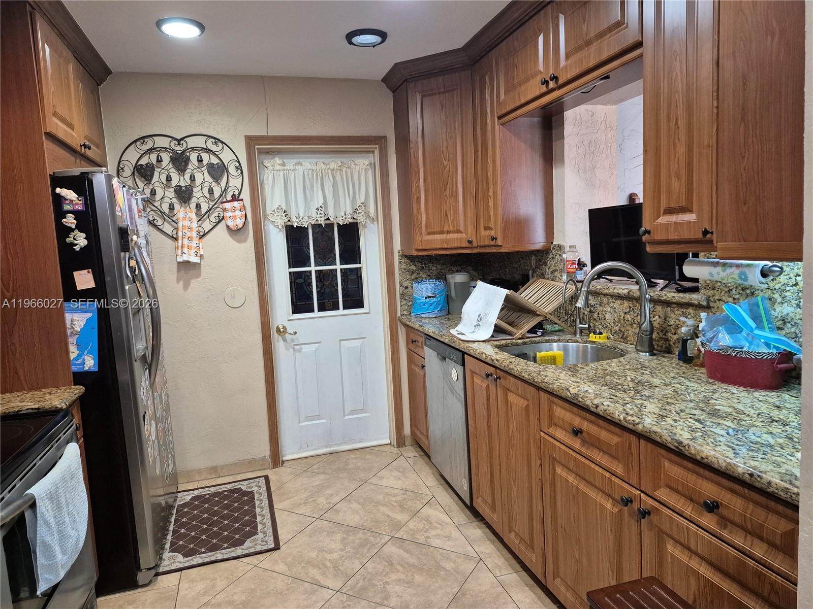 16721 Southwest 298th Terrace Homestead, FL 33030 - Photo 5 of 19 a kitchen with stainless steel appliances granite countertop a sink stove and refrigerator