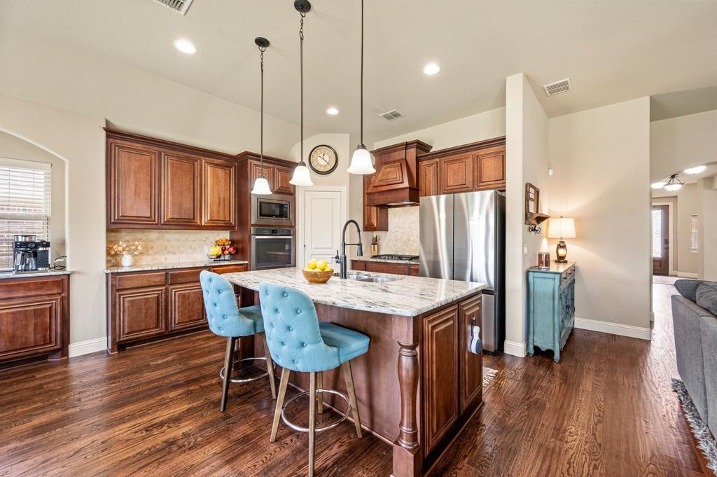 5209 Edgebrook Way Fort Worth, TX 76244 - Photo 2 of 33 a kitchen with stainless steel appliances kitchen island granite countertop wooden floor window and refrigerator
