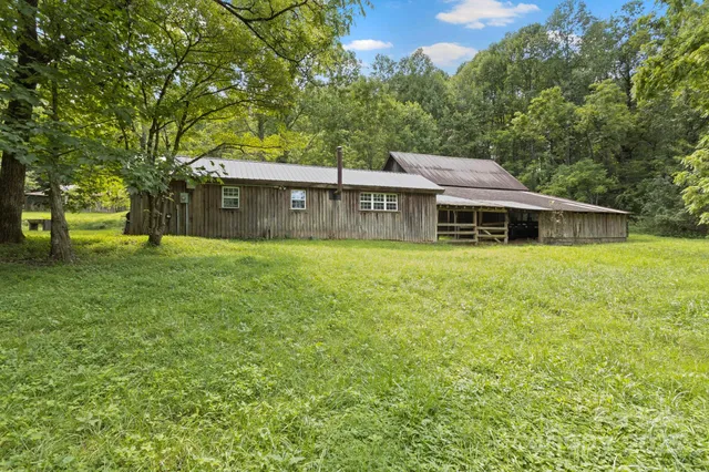 a view of a house with a big yard and large trees