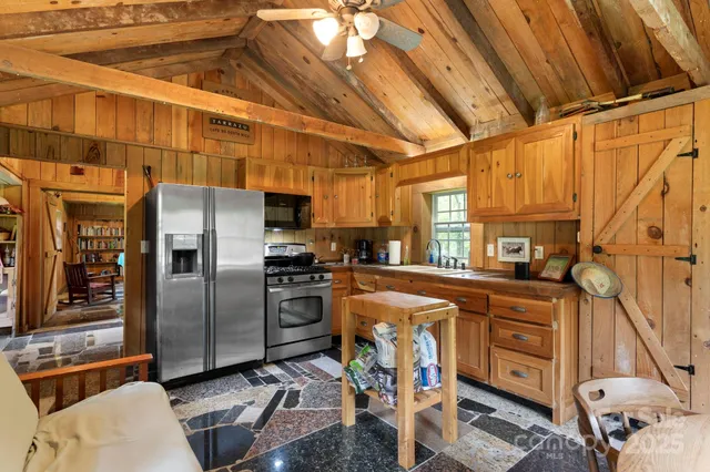 a kitchen with stainless steel appliances granite countertop a refrigerator and a stove top oven